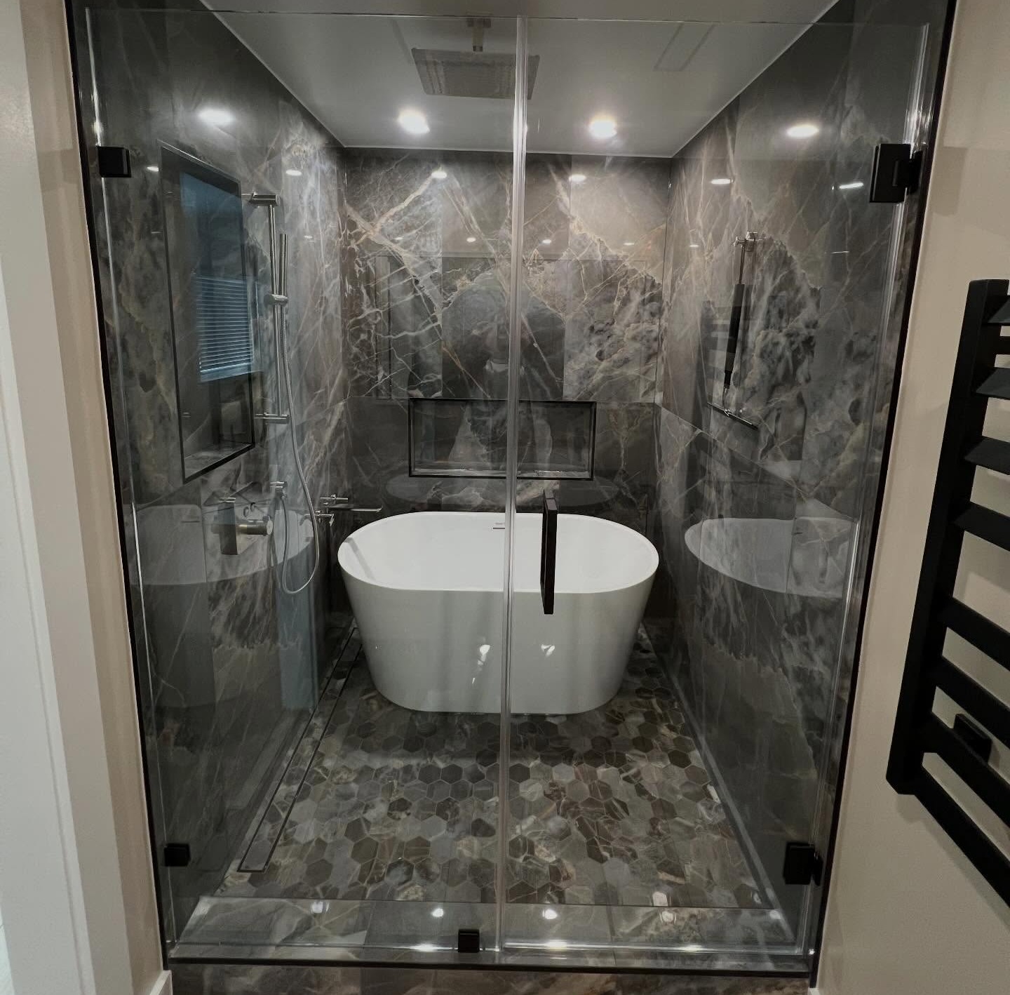 Complete bathroom remodel designed by the homeowner which we brought to life with new shower, tub, tiles, and more